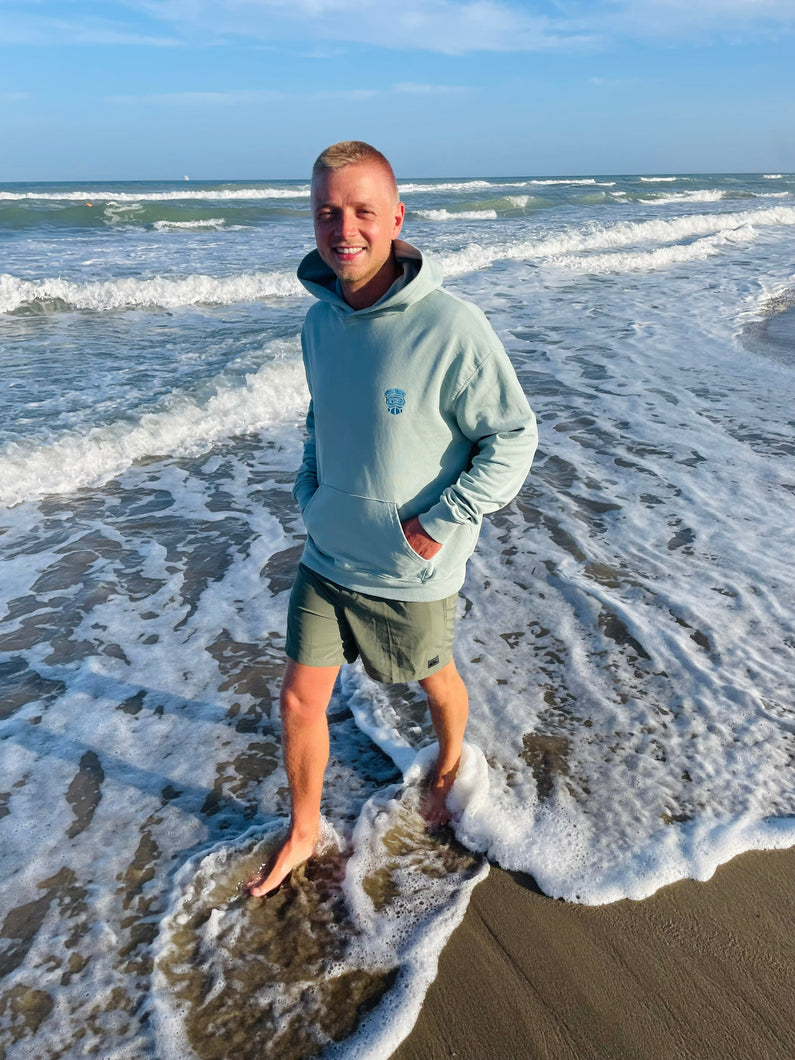 Türkiser Hoodie am Strand